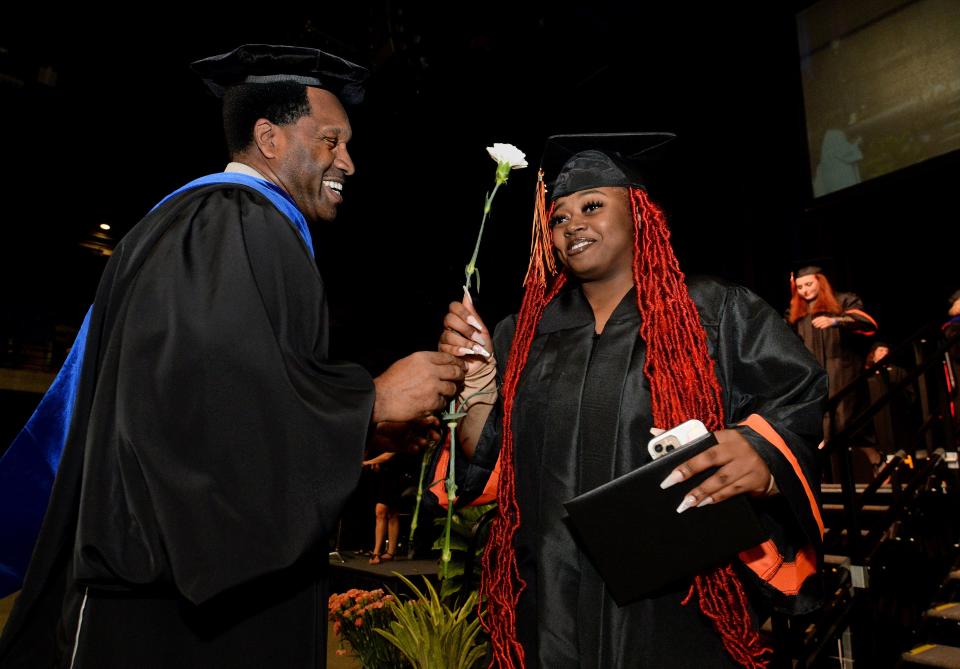 Amari Bunch, right, is handed a flower from Lanphier High School Principal Artie Doss after receiving her diploma during the school's graduation ceremony at the BoS Center on June 4, 2022.