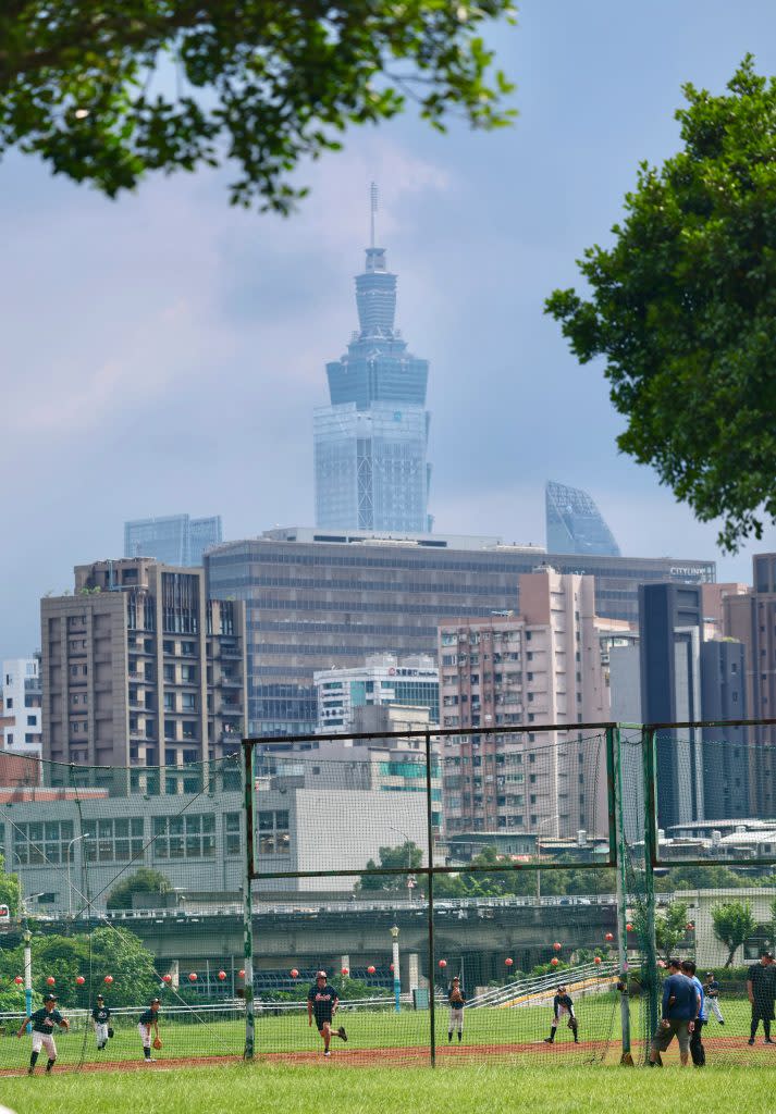 全台炎熱，氣象署22日持續發布高溫燈號資訊，國健署建議避免在上午10時至下午2時之間出門。圖為台北市民眾午後頂著高溫在河濱公園打球運動。（中央社）