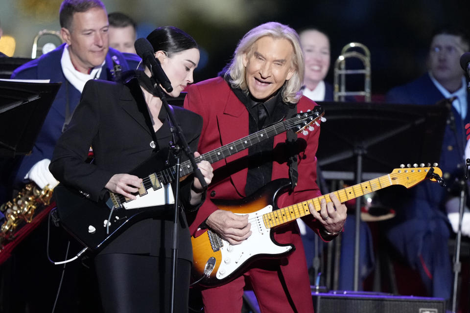 Joe Walsh and St. Vincent perform after President Joe Biden and first lady Jill Biden lit the National Christmas Tree on the Ellipse, near the White House in Washington, Thursday, Nov. 30, 2023. (AP Photo/Mark Schiefelbein)