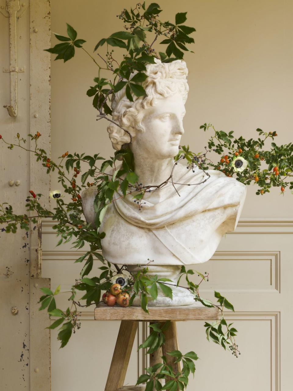 <p>Busts wrapped with flowering vines work just as well in an entry as they would on a large-scale dining table. Try a showstopping floral arrangement with fruits and fall flowers.</p>