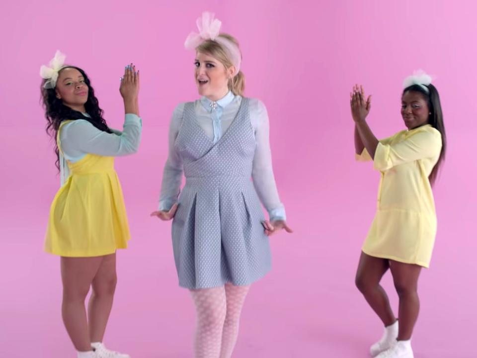 Meghan Trainor in between two backing dancers.