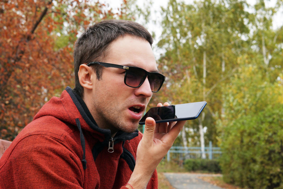 Man yelling into phone in a park