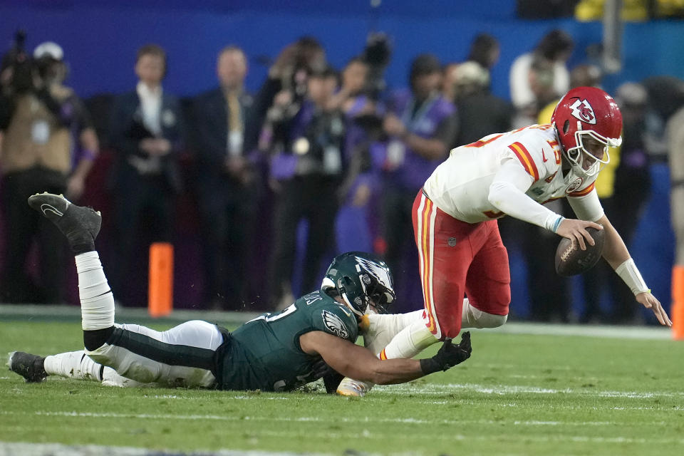 El linebacker T.J. Edwards (izquierda) de los Eagles de Filadelfia derriba al quarterback Patrick Mahomes de los Chiefs de Kansas City durante el primer tiempo del Super Bowl 57, en Glendale, Arizona, el domingo 12 de febrero de 2023. (AP Foto/Marcio J. Sánchez)