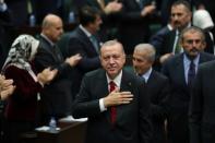 Turkish President Tayyip Erdogan greets members of parliament from his ruling AK Party as he arrives a meeting at the Turkish parliament in Ankara