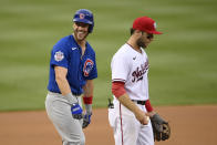 Chicago Cubs' Patrick Wisdom, left, reacts toward the dugout after he reached third on a fielding error by Washington Nationals right fielder Juan Soto (not shown) during the first inning of a baseball game, Saturday, July 31, 2021, in Washington. Nationals third baseman Carter Kieboom, right, looks on. (AP Photo/Nick Wass)