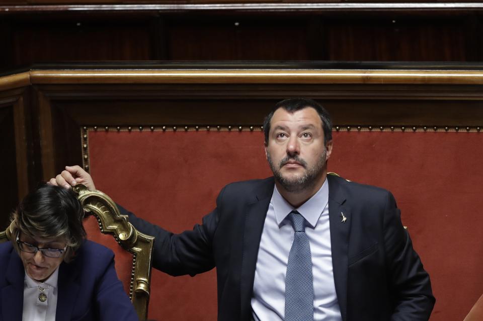 Italian Interior Minister and Vice Premier Matteo Salvini looks up at the Italian Senate, in Rome, Wednesday, March 20, 2019. The Senate is scheduled to vote on whether to lift Parliamentary immunity on Salvini in order for him to be prosecuted by a special tribunal for government ministers for suspected abduction, illegal arrest and abuse of office when he refused to let rescued migrants who were not minors or ill off the Italian Coast Guard Diciotti ship last August. At left is Italian Minister of Public Administration Giulia Bongiorno. (AP Photo/Alessandra Tarantino)