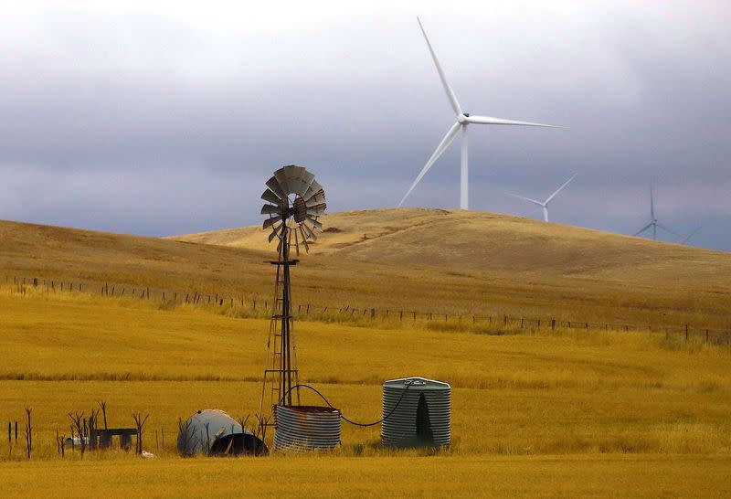 FILE PHOTO: An old windmill stands in front of wind turbines in a paddock near the Hornsdale Power Reserve, featuring the world's largest lithium ion battery made by Tesla, located on the outskirts of the South Australian town of Jamestown