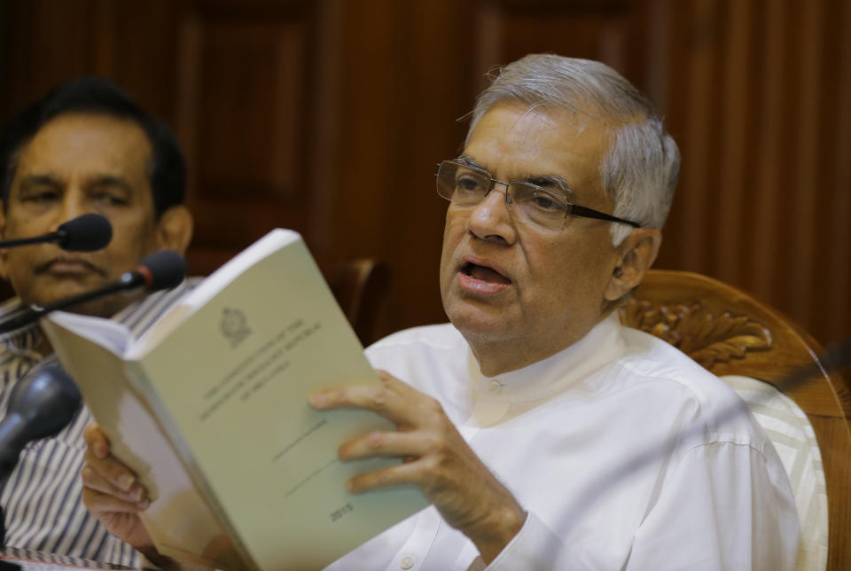 Sri Lanka's sacked prime minister Ranil Wickremesinghe holds a copy of the constitution of Sri Lanka as he attends a media briefing at his official residence in Colombo, Sri Lanka, Monday, Oct. 29, 2018. (AP Photo/Eranga Jayawardena)