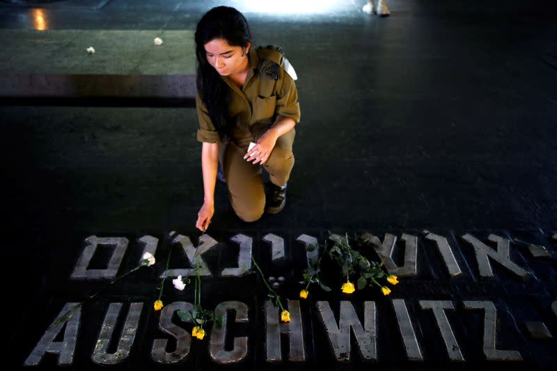 FILE PHOTO: An Israeli soldier places a flower next to the name of a former death camp as she visits the Hall of Remembrance at the Yad Vashem World Holocaust Remembrance Center, on the annual Israeli Holocaust Remembrance Day, in Jerusalem