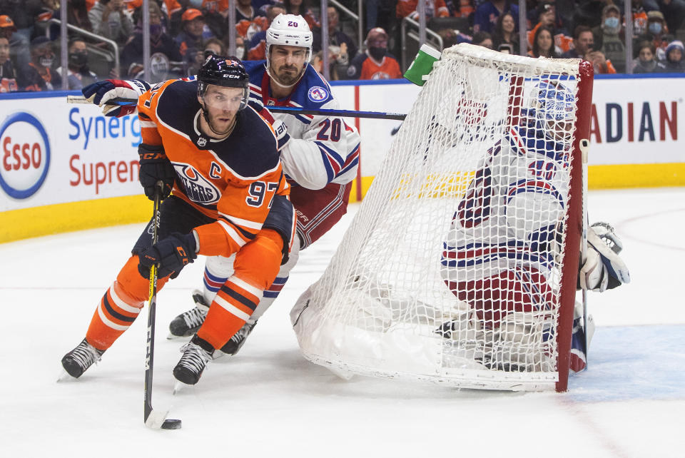 New York Rangers' Chris Kreider (20) chases Edmonton Oilers' Connor McDavid (97) during overtime in an NHL hockey game Friday, Nov. 5, 2021, in Edmonton, Alberta. (Jason Franson/The Canadian Press via AP)