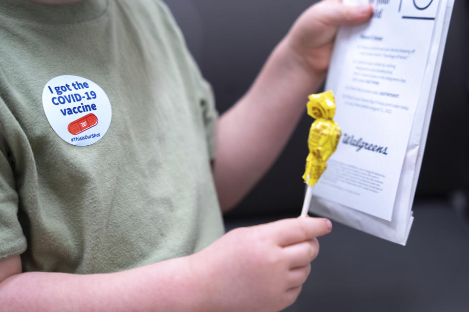 Three year-old Fletcher Pack holds a lollipop after receiving the Moderna COVID-19 vaccination at Walgreens pharmacy Monday, June 20, 2022, in Lexington, S.C. Today marked the first day COVID-19 vaccinations were made available to children under 5 in the United States. (AP Photo/Sean Rayford)