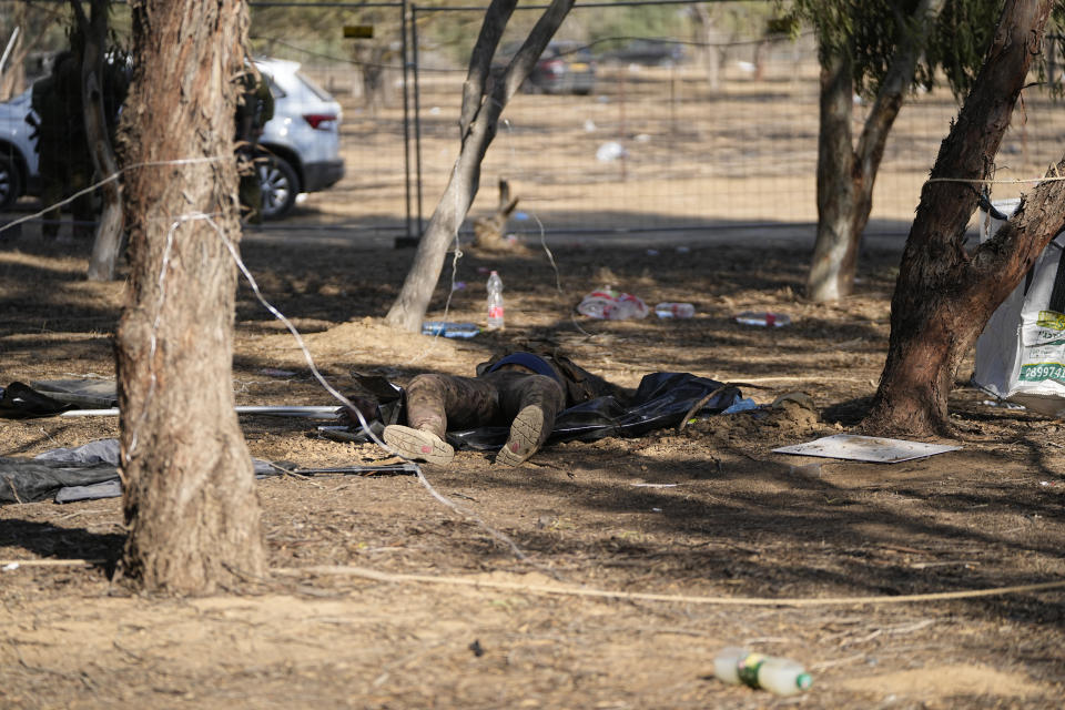 The body of a killed Hamas militant lies on the ground at the site of a music festival, near the border with Gaza Strip in southern Israel, Thursday. Oct. 12, 2023. At least 260 Israeli festivalgoers were killed during the attack last Saturday. (AP Photo/Ohad Zwigenberg)