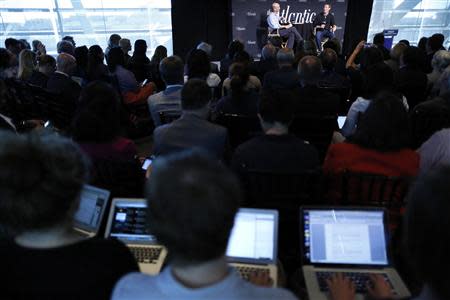 People work on laptops at the back of the room as Facebook CEO Mark Zuckerberg (R, onstage) speaks during an onstage interview for with James Bennet (L, onstage) of the Atlantic Magazine in Washington, September 18, 2013. REUTERS/Jonathan Ernst