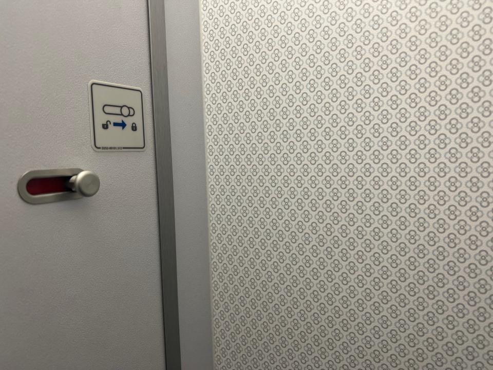 Flying on La Compagnie all-business class airline from Paris to New York — the La Compagnie logo on the wall in the lavatory.
