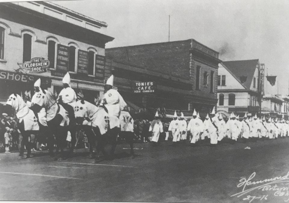 In this image provided by the Tulare County Library, members of the KKK parade through Porterville.