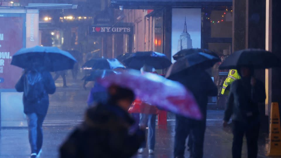 Pedestrians carry umbrellas as they walks through heavy rain in Times Square in New York City on Monday, December 18, 2023. - John Angelillo/UPI/Shutterstock