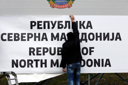 Workers set up a sign with Macedonia's new name at the border between Macedonia and Greece, near Gevgelija, Macedonia February 13, 2019. REUTERS/Ognen Teofilovski