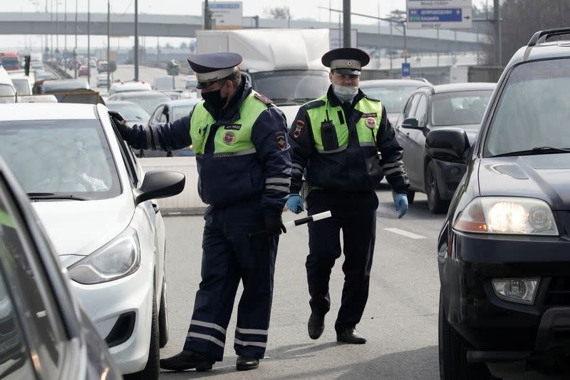 Traffic police officers wearing protective masks work at a checkpoint in Moscow