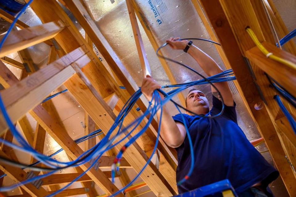 Paradise resident Jason Buzzard installs wiring in his rebuilt home in Paradise on Oct. 8. “This is our home, this is where my daughter is going to grow up.There was no question we were going to rebuild,” said Buzzard.