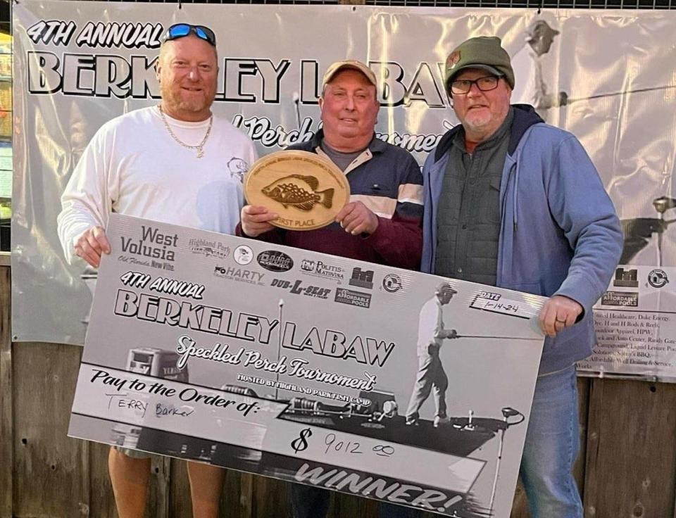 Stephen LaBaw and tournament organizer Donnie McCormick flank Terry Barker, who is presented with the spoils after winning the fourth annual Berkeley LaBaw Memorial Speck Fishing Tournament last weekend at Highland Park in DeLand