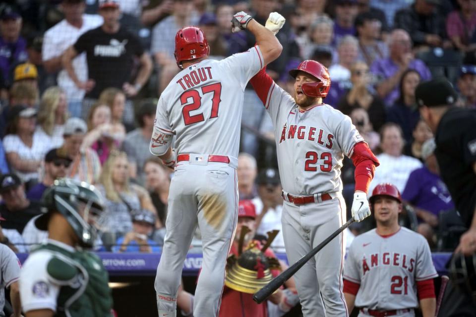 The Angels' Mike Trout leaps into the air and celebrates with deck hitter Brandon Drury after his solo home run
