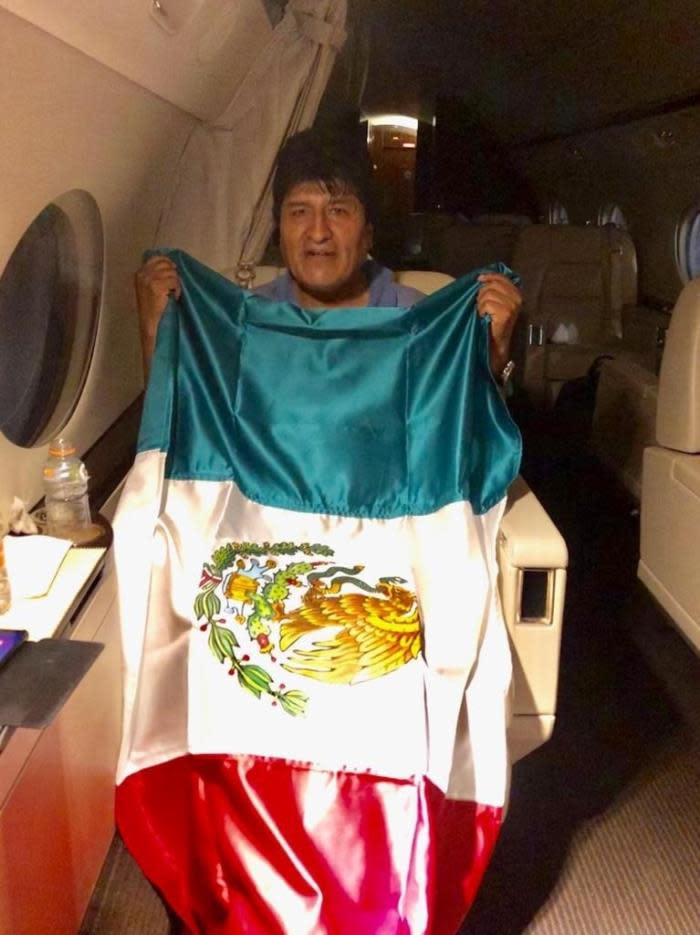 Fotografía cedida por la Cancillería mexicana que muestra al expresidente de Bolivia Evo Morales mientras posa con una bandera mexicana, durante su viaje en un avión de la Fuerza Aérea Mexicana (Bolivia). EFE/ Cancillería De México MÁXIMA CALIDAD DISPONIBLE SOLO USO EDITORIAL NO VENTAS