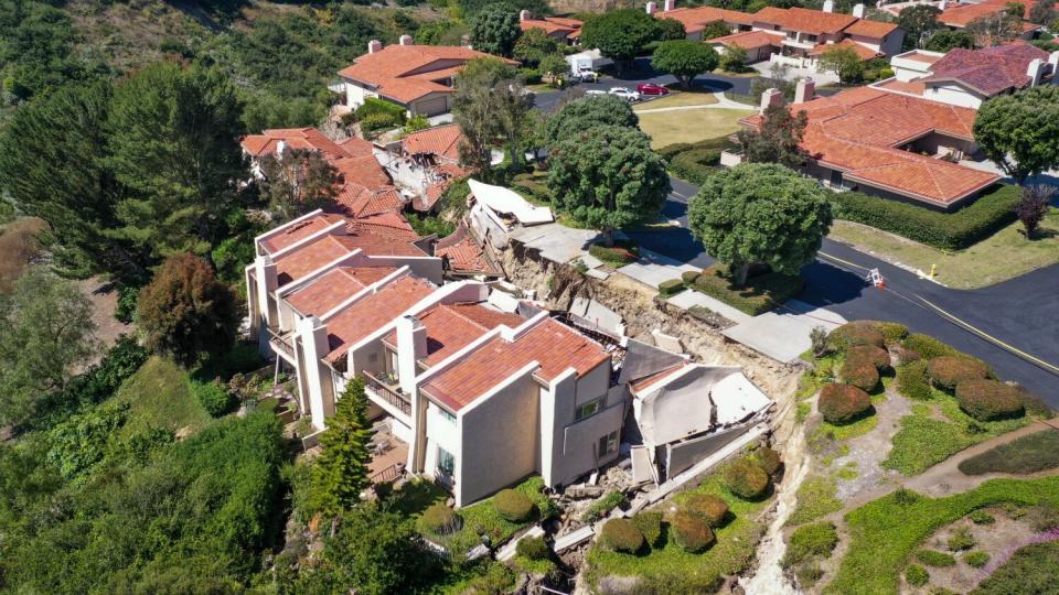 A drone view of cracked homes sliding down a hill