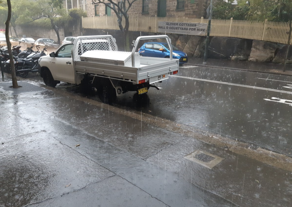 Rain pours down in The Rocks on Friday morning. Source: Twitter/ Paul Upham