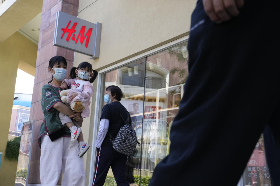 A woman and child wearing masks pass by a H&M store in Beijing on Thursday, June 3, 2021. The Chinese government has accused H&M, Nike, Zara and other brands of importing unsafe or poor quality children's clothes and other goods, adding to headaches for foreign companies after Beijing attacked them over complaints about possible forced labor in the country's northwest. (AP Photo/Ng Han Guan)