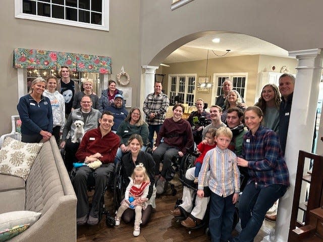 Jason Kolb, seated with his dog Daisy on his lap, with the members of his new SCI group made up of people from Northeast Ohio who have suffered spinal cord injuries. The group meets about once a month at Kolb's home for dinner.