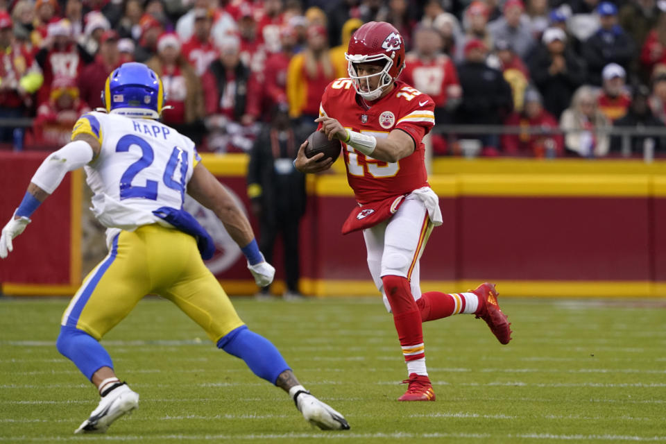 Kansas City Chiefs quarterback Patrick Mahomes (15) scrambles up field ahead of Los Angeles Rams safety Taylor Rapp (24) during the first half of an NFL football game Sunday, Nov. 27, 2022, in Kansas City, Mo. (AP Photo/Ed Zurga)