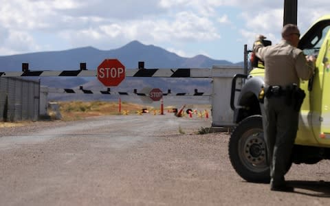 Law enforcement guard the entrance to Area 51 as an influx of tourists responding to a call to 'storm' Area 51 - Credit: Reuters