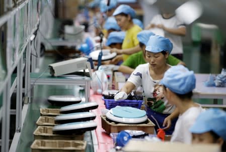 Employees work on the production line of a robot vacuum cleaner at a factory of Matsutek in Shenzhen