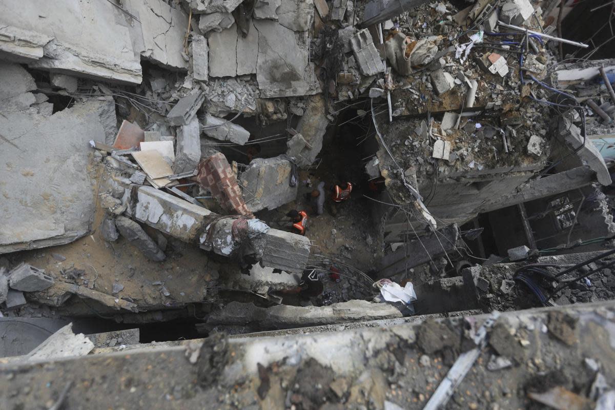 Palestinians look at the destruction after an Israeli strike on residential building in Rafa <i>(Image: AP Photo/Ismael Abu Dayyah)</i>
