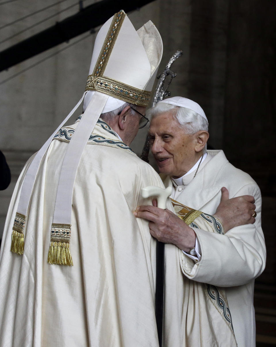 FILE - Pope Emeritus Benedict XVI, right, hugs Pope Francis in St. Peter's Basilica during the ceremony marking the start of the Holy Year, at the Vatican, on Dec. 8, 2015. Pope Benedict XVI’s 2013 resignation sparked calls for rules and regulations for future retired popes to avoid the kind of confusion that ensued. Benedict, the German theologian who will be remembered as the first pope in 600 years to resign, has died, the Vatican announced Saturday Dec. 31, 2022. He was 95. (AP Photo/Gregorio Borgia, File)