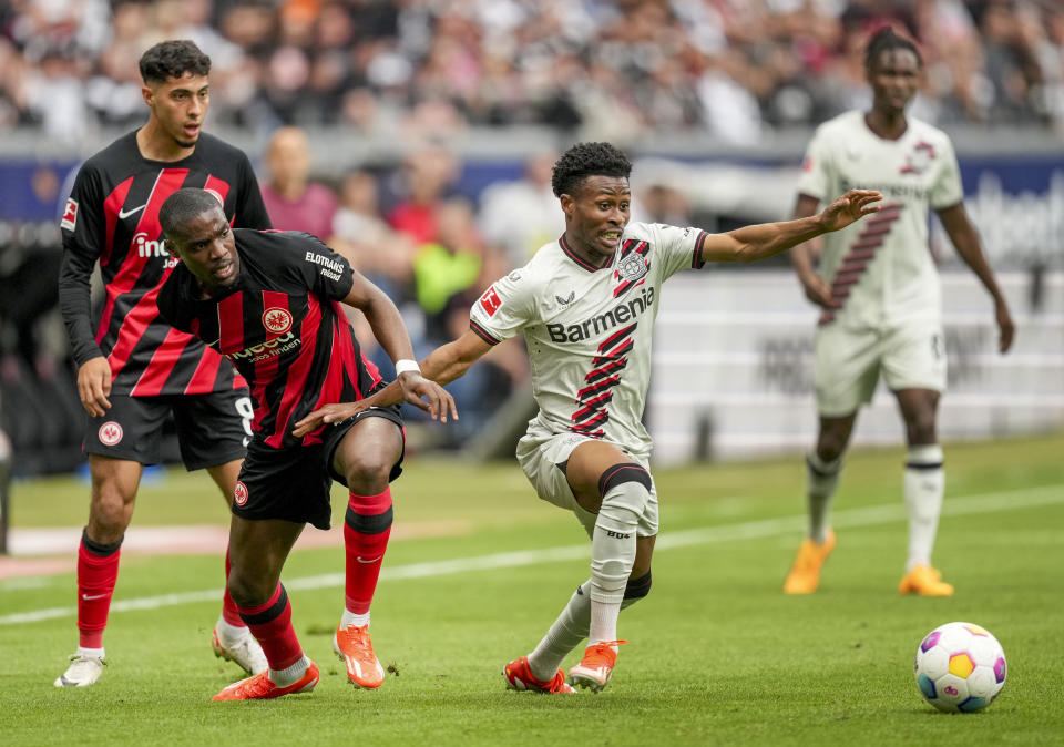 Frankfurt's Niels Nkounkou, left, and Leverkusen's Nathan Tella challenge for the ball during the German Bundesliga Soccer match between Eintracht Frankfurt and Bayer Leverkusen in Frankfurt, Germany, Sunday, May 5, 2024. (AP Photo/Michael Probst)