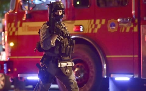 An armed police officer at the scene of the shooting in Toronto - Credit: Canadian Press/REX/Shutterstock 