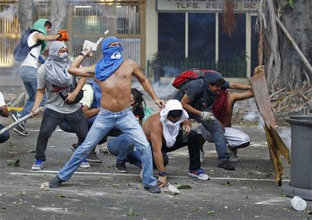 Demonstrators confront police as they protest against the government of President Nicolas Maduro in Caracas, February 22, 2014. REUTERS/Carlos Garcia Rawlins