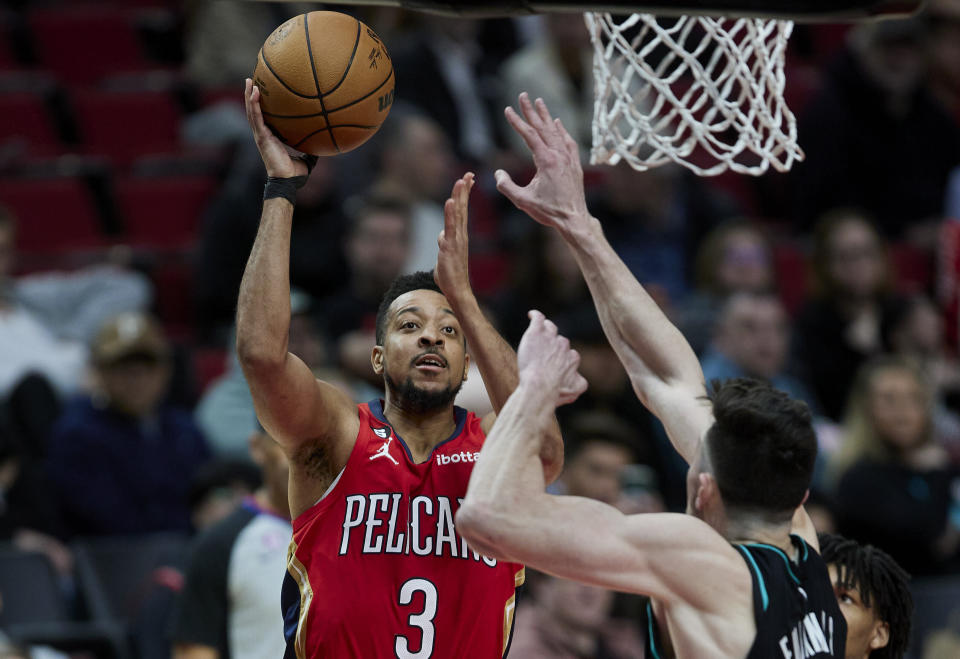New Orleans Pelicans guard CJ McCollum, left, shoots over Portland Trail Blazers forward Drew Eubanks during the second half of an NBA basketball game in Portland, Ore., Monday, March 27, 2023. (AP Photo/Craig Mitchelldyer)