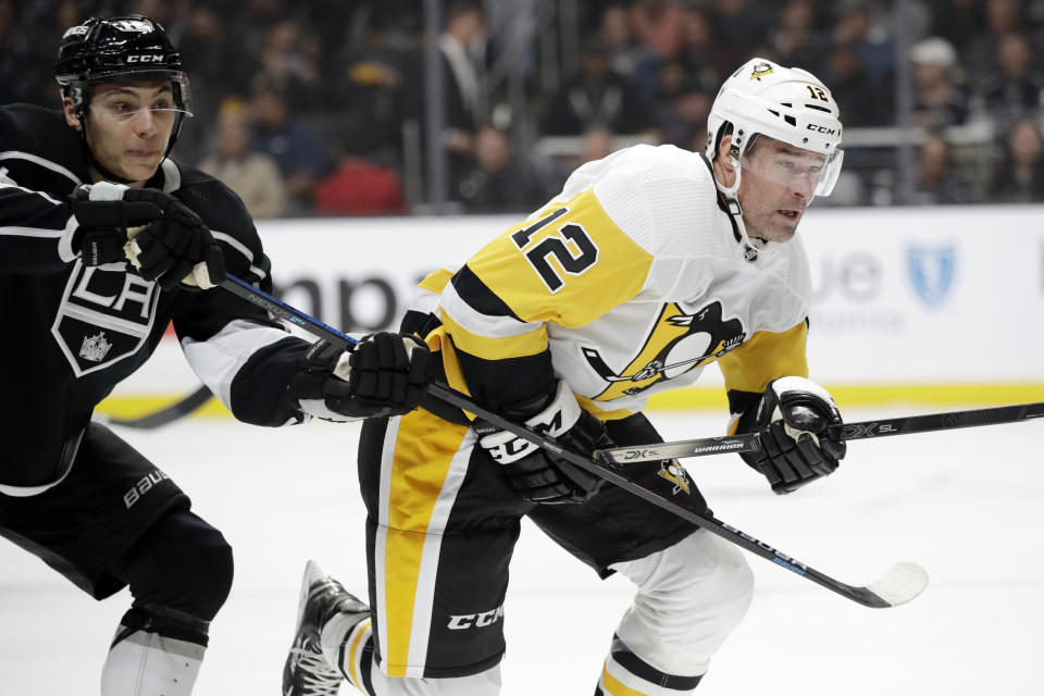 Pittsburgh Penguins' Patrick Marleau (12) is defended by Los Angeles Kings' Trevor Moore, left, during the first period of an NHL hockey game Wednesday, Feb. 26, 2020, in Los Angeles. (AP Photo/Marcio Jose Sanchez)