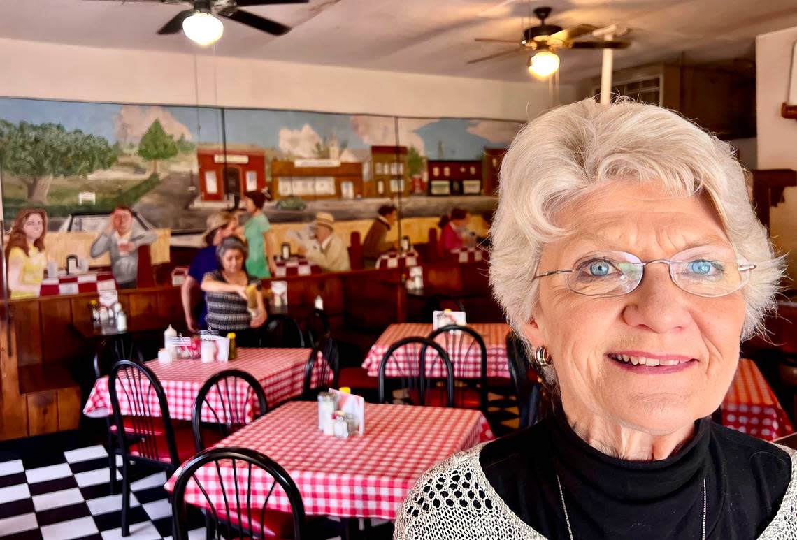 Claudette Finley at the Montgomery Street Cafe in Fort Worth Jan. 7, 2023. The background mural depicts the cafe in the 1950s.