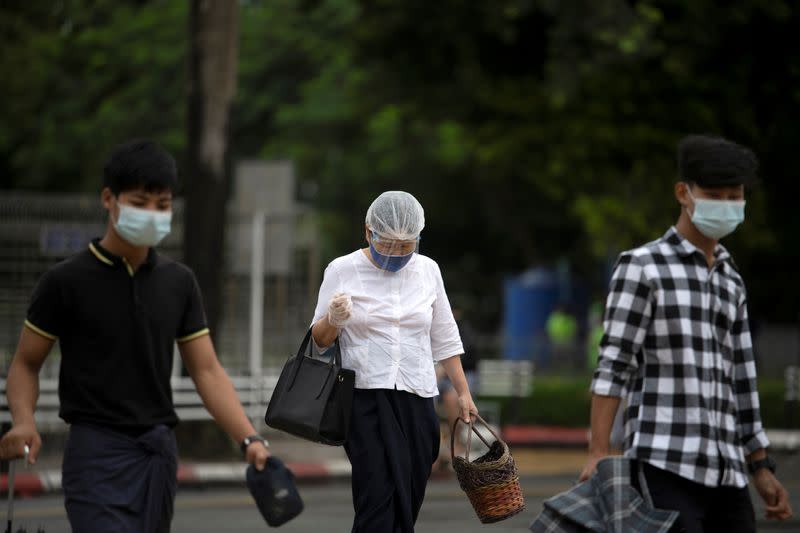 Pedestrians cross a street amid the COVID-19 pandemic in Yangon