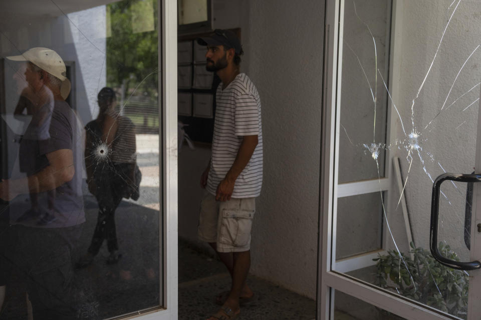 A group of Israelis on an educational tour visit the dining hall that was damaged during the Oct. 7, Hamas attack on Israel in Kibbutz Nir Oz, on Friday, June 21, 2024. A new kind of tourism has emerged in Israel in the months since Hamas’ Oct. 7 attack. For celebrities, politicians, influencers and others, no trip is complete without a somber visit to the devastated south that absorbed the brunt of the assault near the border with Gaza. (AP Photo/Ohad Zwigenberg)