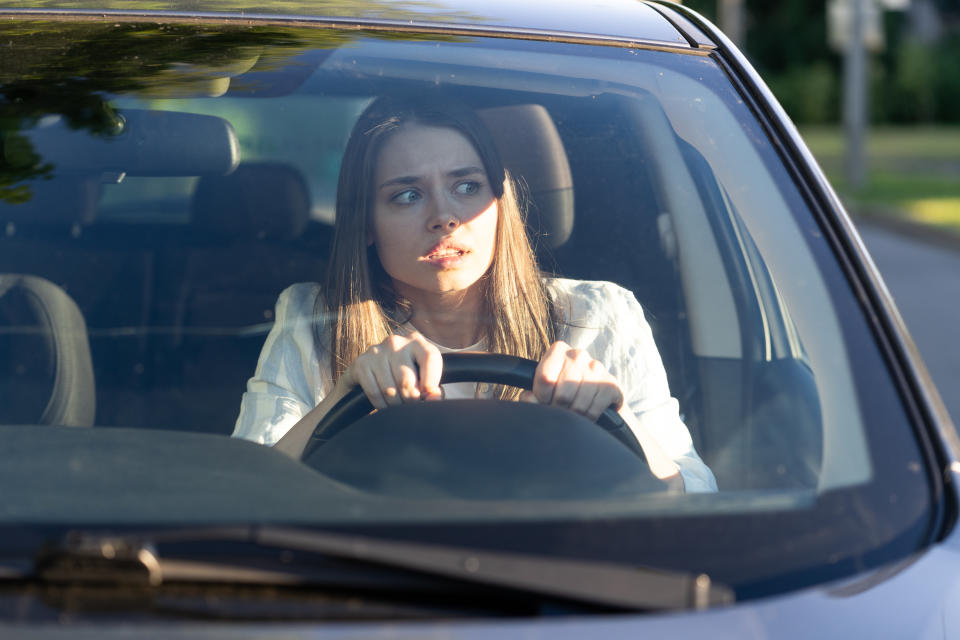 Nervous female driver looking around in car. Source: Getty Images