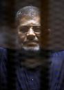 FILE PHOTO: Former Egyptian President Mohamed Mursi looks on during his appearance in court on the outskirts of Cairo, Egypt