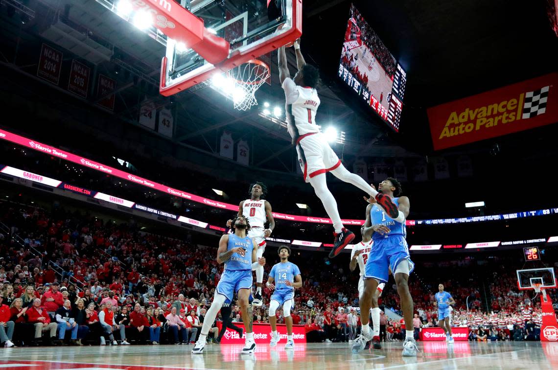 N.C. State’s Jarkel Joiner (1) slams in two on an alley-oop from Terquavion Smith (0) late in the second half of N.C. State’s 77-69 victory over UNC at PNC Arena in Raleigh, N.C., Sunday, Feb. 19, 2023.
