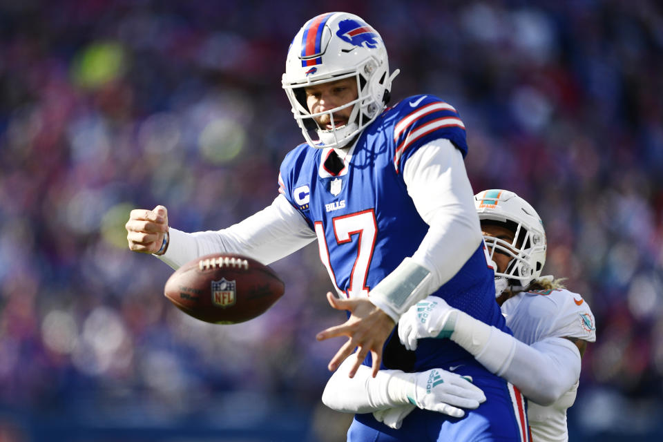 Buffalo Bills quarterback Josh Allen (17) is hit by Miami Dolphins linebacker Duke Riley (45) during the first half of an NFL wild-card playoff football game, Sunday, Jan. 15, 2023, in Orchard Park, N.Y. (AP Photo/Adrian Kraus)