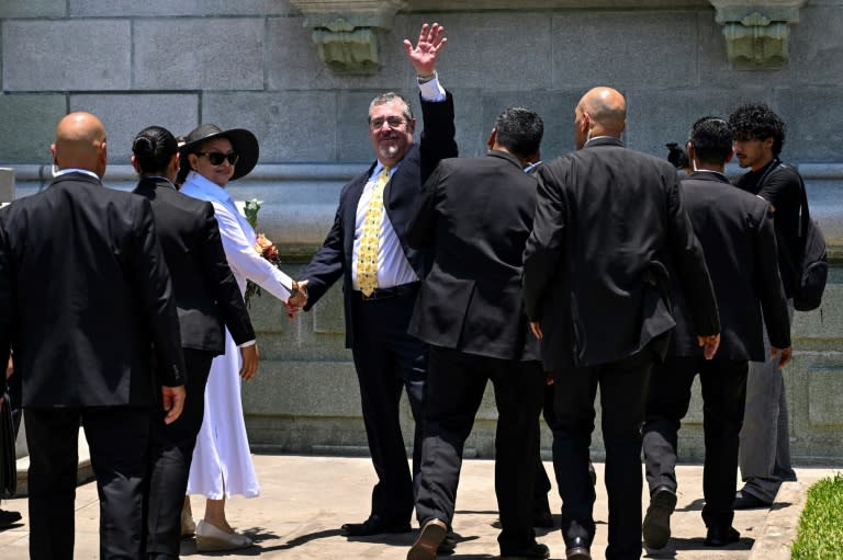 El presidente de Guatemala, Bernardo Arévalo (centro), saluda junto a su esposa Lucrecia Peinado al llegar al Palacio de la Cultura durante una ceremonia por los 100 días de su gobierno, en Ciudad de Guatemala, el 23 de abril de 2024 (JOHAN ORDONEZ)