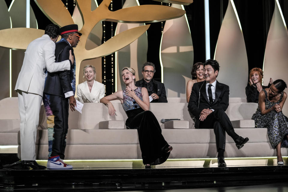 FILE - In this July 17, 2021 file photo Jury president Spike Lee, second from left, accidentally reveals the film 'Titane' as the winner of the Palme d'Or as jury members Tahar Rahim, from left, Jessica Hausner, Melanie Laurent Kleber Mendonca Filho, Maggie Gyllenhaal, Song Kang-ho, Mylene Farmer, and Mati Diop react during the awards ceremony at the 74th international film festival, Cannes, southern France. (AP Photo/Vadim Ghirda, File)