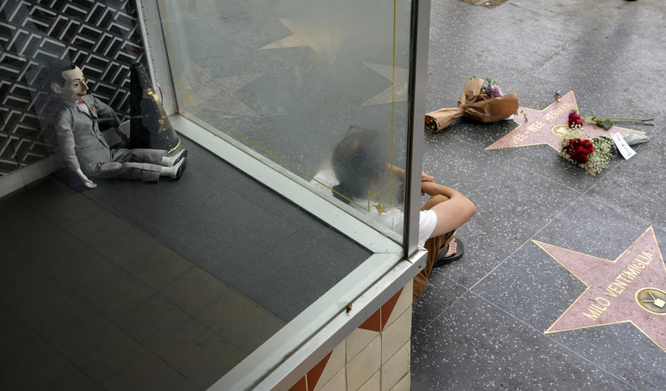 A Pee-wee Herman doll is pictured sitting in a window near the character's star on the Hollywood Walk of Fame, Monday, July 31, 2023, in Los Angeles. Paul Reubens, the actor and comedian who created the character, died Sunday night, July 30, after a six-year struggle with cancer. (AP Photo/Chris Pizzello)